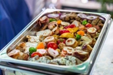 Canlı bir açık büfe tabağında çeşitli ızgara etler, renkli sebzeler ve süslü süsler, canlı bir etkinlikte cazip misafirler sergileniyor. Çanak, çekici sunumuyla dikkatleri üzerine çekiyor..