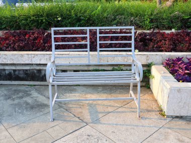 Oturmak için beyaz demir bahçe bankı