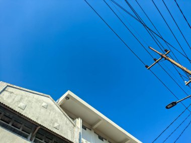 a blue sky with electricity poles and wires