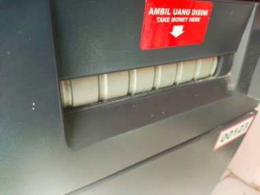 ATM 'nin para yuvası. ATM 'den para çektim. Surabaya, Endonezya - 6 Maret 2024
