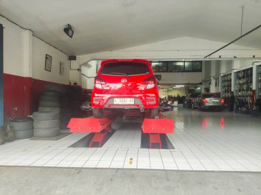 Agya 'nın Toyota arabası dengeleniyor ve bakımını yapıyor. Surabaya, Endonezya - 13 Mayıs 2024