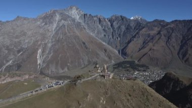 Georgia 'daki büyük Kazbegi dağının arka planında duran bir kilisenin güzel bir görüntüsü.