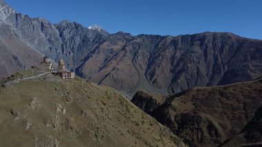 Stepantsminda köyünü çevreleyen güzel dağlar ve tepede yalnız bir kilise.
