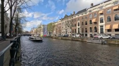 Amsterdam 'ın kanallarından bir tekne geçiyor. Güzel manzara