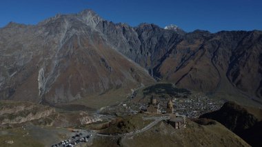 Unbelievable view of the famous Gergeti Church and Stepantsminda village at the foot of the mountain. Georgia clipart