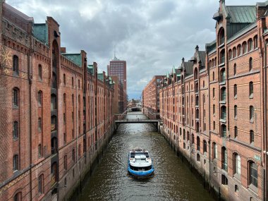 Gemi, Hamburg 'daki güzel depoların arasında kanal boyunca ilerliyor.