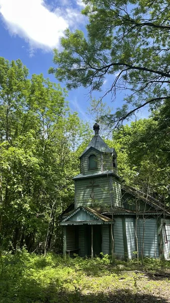 ウクライナの村にある古い木造教会青い空と背後にある森 — ストック写真