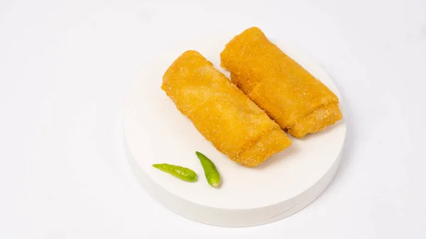 Risol, a traditional Indonesian savory snack containing vegetables mixed with layers of chicken and bread crumbs. Risol and green chilies isolated on a white background