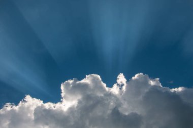 Güneş gökyüzündeki beyaz bulutlarda parlıyor..