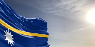 Nauru ulusal bayrak kumaşı güzel gri arka planda sallanıyor..