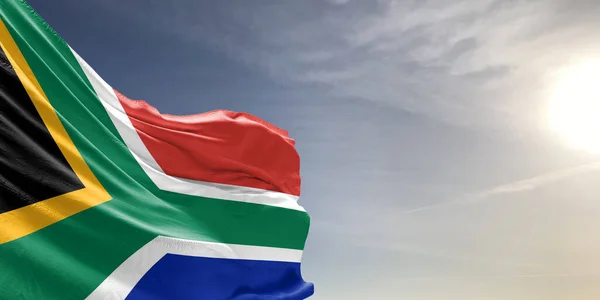 South Africa national flag cloth fabric waving on beautiful grey sky Background.