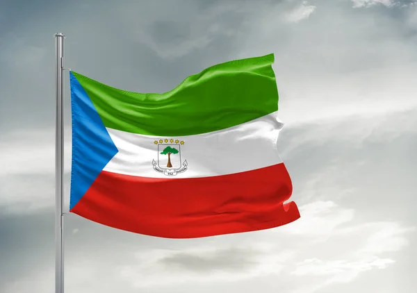 Stock image Equatorial Guinea national flag cloth fabric waving on beautiful grey sky Background.