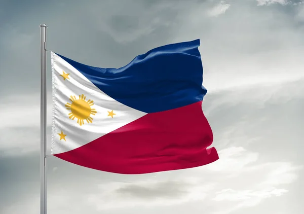美しい灰色の空に手を振っているフィリピン国旗布背景 — ストック写真