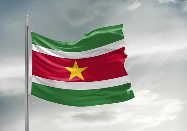 美しい灰色の空に揺れるスリナム国旗布背景 — ストック写真