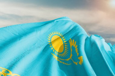 Kazakistan ulusal bayrak kumaşı güzel gri arka planda dalgalanıyor.
