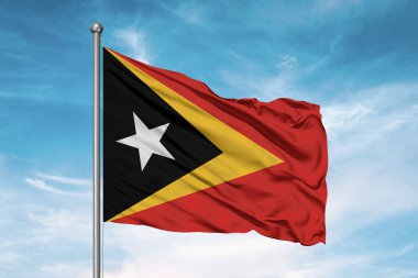 Doğu Timor (Timor-Leste). Ulusal bayrak kumaşı güzel bulutlu arka planda dalgalanıyor.