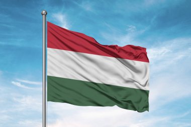 Macaristan ulusal bayrak kumaşı güzel bulutlu arka planda dalgalanıyor.