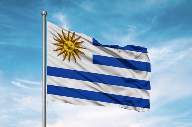 Uruguay ulusal bayrak kumaşı güzel bulutlu arka planda dalgalanıyor.