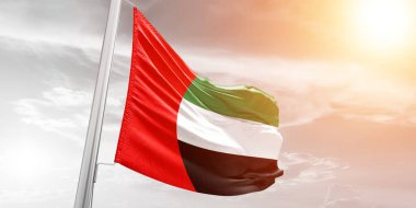 Birleşik Arap Emirlikleri ulusal bayrak kumaşı güzel bulutlu arka planda dalgalanıyor.