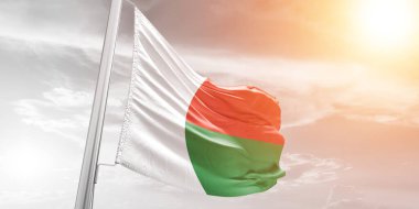 Madagaskar ulusal bayrak kumaşı güzel bulutlu arka planda dalgalanıyor.