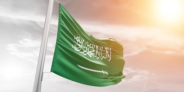 Suudi Arabistan ulusal bayrak kumaşı güzel bulutlu arka planda dalgalanıyor.