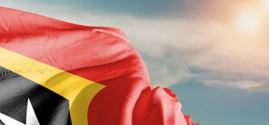 Doğu Timor (Timor-Leste) Ulusal bayrak kumaşı güzel bir arka planda dalgalanıyor.