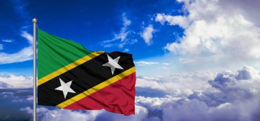 Saint Kitts ve Nevis Ulusal Bayrak Kumaşı Güzel bulutlu arka planda sallanıyor.