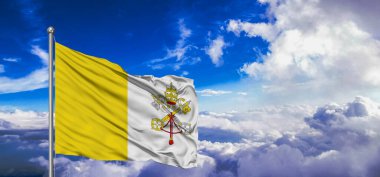 Vatikan Ulusal Bayrak Kumaşı Güzel bulutlu gri arka planda sallanıyor.