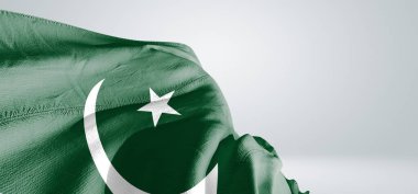 Pakistan bayrağı kumaşı açık gri arka planda sallanıyor..