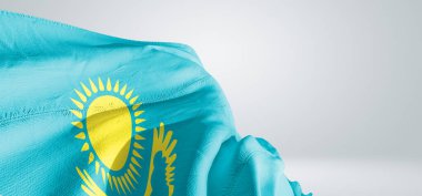 Kazakistan ulusal bayrak kumaşı güzel gri ışık arka planında dalgalanıyor.