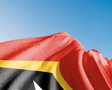 Doğu Timor (Timor-Leste) Ulusal bayrak kumaşı güzel gökyüzü mavi arka planda dalgalanıyor.