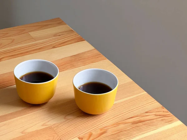 Twee Gele Kopjes Met Warme Koffie Houten Tafel — Stockfoto