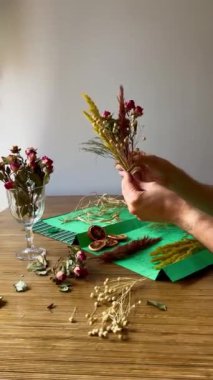 Kurumuş çiçek buketi hazırlayan erkek bir çiçekçinin elleri.