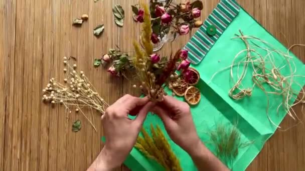 一个男花匠的手正在木桌上做一束干花 — 图库视频影像