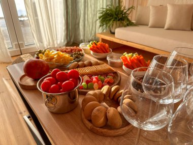 Deniz manzaralı bir tepedeki küçük bir kır evinin parlak oturma odasında öğle yemeği.