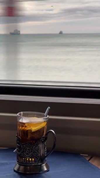 Pencerenin Arkasındaki Uzun Mesafeli Trende Markalı Bir Camda Çay Fincanı — Stok video