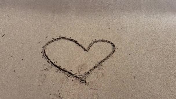 海浪冲走了沙滩上的心形 — 图库视频影像