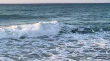 Mavi gökyüzüne karşı yoğun, dinamik fırtına dalgaları.