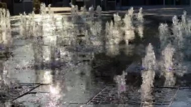 Çeşmede koşan bir çocuğun silueti, etrafa su sıçrıyor..