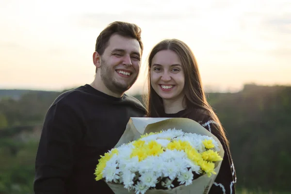 beautiful couple in love.Real sincere emotions.husbands wife.happy couple.Hugs.Nature portrait.Active leisure.people laugh.Love and relationship.Young people.happy moment.dating in nature.man hugging.love story.man gave flowers.woman with a bouquet.