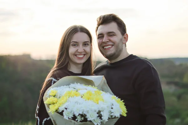 beautiful couple in love.Real sincere emotions.husbands wife.happy couple.Hugs.Nature portrait.Active leisure.people laugh.Love and relationship.Young people.happy moment.dating in nature.man hugging.love story.man gave flowers.woman with a bouquet.