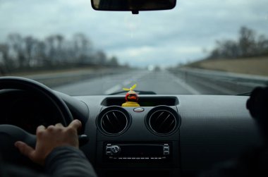 Arabanın içinden Bokeh, ışıklar ve lastik bir ördekle çekilmiş bir fotoğraf. Arabayla seyahat et. Arabadan bak. Araba ön camı. Güzel manzara. Dashboard. Otomobil sürüşü. Araba gezisi.