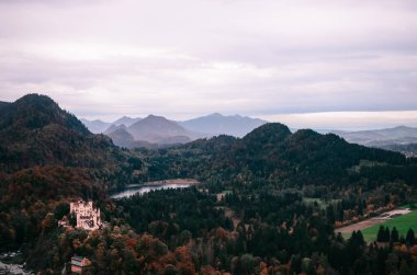 Doğa manzarası çok güzel. Kalenin ve doğanın yukarıdan görünüşü. Bavyera 'daki dağlarda kalenin manzarası. Göle ve dağlara bakan manzara. Bavyera' da seyahat. Turistik yerler..