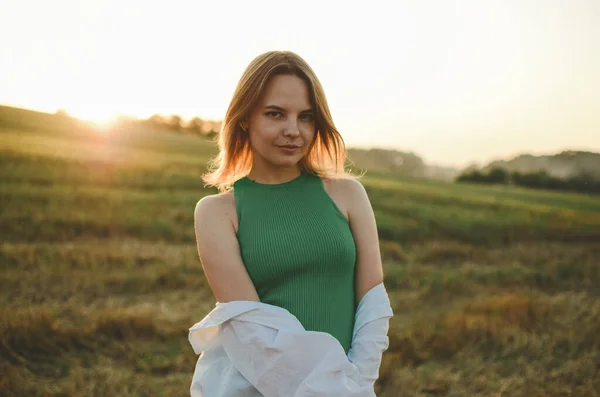Ένα Κορίτσι Ένα Πράσινο Φόρεμα Στέκεται Στο Φόντο Του Ηλιοβασιλέματος — Φωτογραφία Αρχείου
