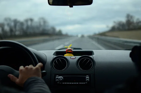 Arabanın içinden Bokeh, ışıklar ve lastik bir ördekle çekilmiş bir fotoğraf. Arabayla seyahat et. Arabadan bak. Araba ön camı. Güzel manzara. Dashboard. Otomobil sürüşü. Araba gezisi.
