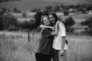 Bahar mevsiminde bir tarlada genç güzel kızlar. Grain ile klasik fotoğraf. İki mutlu kızın siyah-beyaz portresi. Doğası gereği kız arkadaşlar. Lezbiyen çiftler..