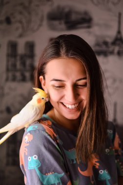 Şirin papağanı olan güzel bir genç kadın. Omzunda papağan olan bir kız. Papağanı olan bir kadın. Bir kız ve bir kuşun arkadaşlığı. Evcil hayvanı olan mutlu bir kız.