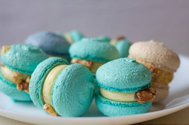 Renkli arkaplanlı lezzetli badem kurabiyeleri.dessert .baking.franch tats.bakery.food teslimatı.macaroons dekoru. Farklı tatlar. Ev yapımı kekler. Kafe reklamı. Güzel tatlı. Narin krema.