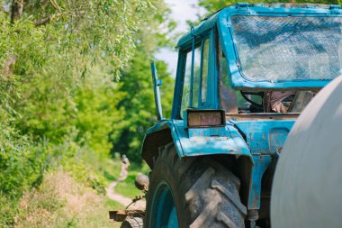 Bir yaz günü bir ormanda traktör. Mavi traktör. Beyaz Rusya antika traktörü. Tarlada iş. Ukrayna 'da tarım ve tarım. Eski traktör, tamirci. Tarım makinelerinin tamiri.