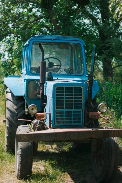old tractor in a field.blue tractor.Belarusian retro vintage tractor.work in the field.farming and agribusiness.Farming in Ukraine.Old working tractor.mechanic driver.repair of agricultural machinery.agrotechnics.ukrainian village.young farmer.